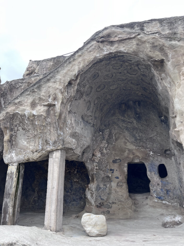 Antik udhugget klippeformation og grotte i den historiske huleby Uplistsikhe med udskårne stensøjler og buer